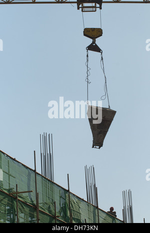 Costruttori che utilizzano una gru per caricare il cemento in un cantiere a Pechino, mentre lavorano alla costruzione di un nuovo edificio sostenuto da ponteggi. © Olli Geibel Foto Stock