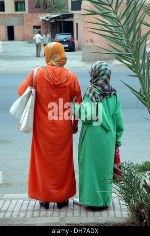 Due donne marocchine attendere di attraversare una strada a Marrakesh. Foto Stock