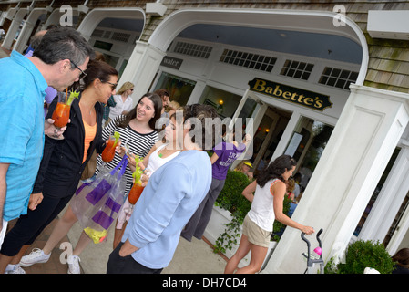 Un gruppo misto di persone bere Bloody Mary's mentre aspetta con altri di essere seduti al di fuori di Babette's restaurant East Hampton Foto Stock