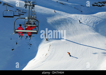 Gli sciatori in una seggiovia al di sopra della discesa in neve fresca con piste di sci in Cauterets ski resort. Foto Stock
