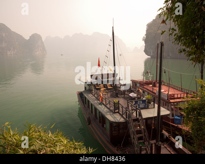 Una vista del calcaree spettacolari formazioni carsiche e le barche ormeggiate nella baia di Halong, Vietnam. Foto Stock