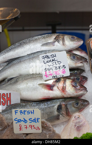 Fish Monger stallo di mercanzia. Appena catturati Spigola. Beresford Mercato del Pesce. Beresford Street, St. Helier, Jersey nelle isole del Canale Foto Stock