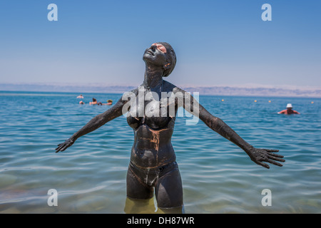 Una donna l'applicazione di fango del Mar Morto cura del corpo in Giordania Foto Stock