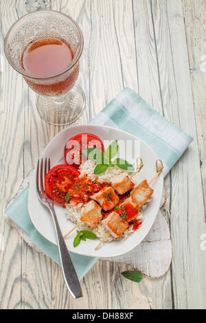 Spiedini di Turchia sul riso con salsa di pomodoro e pomodori grigliati Foto Stock