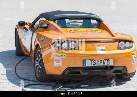 La Tesla Roadster, un americano di vettura sportiva elettrica avente le sue batterie caricate prima che il prologo della e-miglia 2012 da Foto Stock