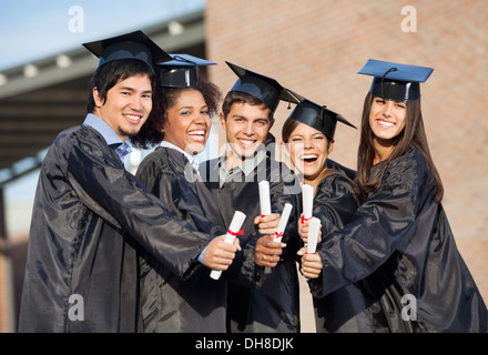 Gli studenti di laurea gli abiti che mostra diplomi del Campus Foto Stock