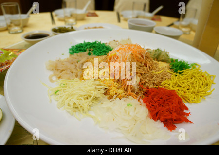 Yee sang o prosperità toss, con insalata di pesce crudo, per celebrare il nuovo anno cinese nei paesi del sud-est asiatico Foto Stock