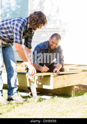 Lavoratori di legno di misura al sito in costruzione Foto Stock