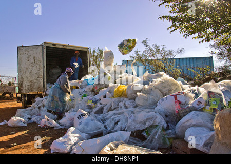 I lavoratori off rifiuti di carico in gran parte da negozi di generi alimentari a sebokeng alla raccolta gestita da mattoni a Orange Farm. È Foto Stock