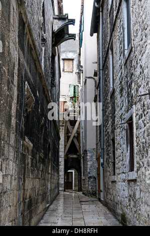 Uno dei molti antichi sentieri di marmo tra edifici alti portando ad un cancello ad arco in corrispondenza di un incrocio, il Palazzo di Diocleziano Split Foto Stock