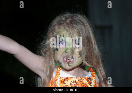 Bambina indossa la faccia di Halloween Paint tirando un volto arrabbiato Foto Stock