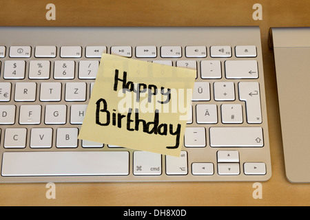 "Buon Compleanno" Post-it sulla tastiera del computer Foto Stock