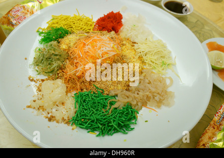 Yee sang o prosperità toss, con insalata di pesce crudo, per celebrare il nuovo anno cinese nei paesi del sud-est asiatico Foto Stock