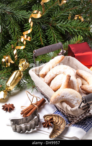 Lo zucchero in casa cookie crescent servita nel cestello con vintage-cookie cutter e doni vicino albero di natale su bianco Foto Stock