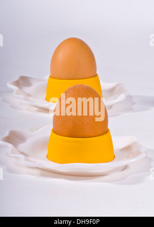 La colazione uova uovo in tazze su sfondo bianco Foto Stock