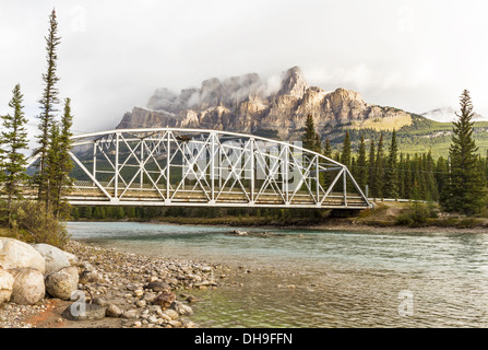 Castle Mountain emerge dalle nuvole al di sopra di un ponte sul Fiume Bow nel Parco Nazionale di Banff, Alberta Foto Stock