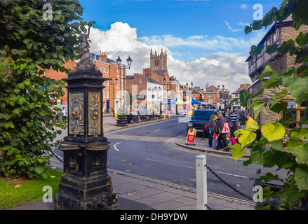 Una vista di Ludlow la vecchia 900 anni con un mercato in disuso ornamentali di punto di acqua che incorniciano la vista sulla vivace piazza Foto Stock