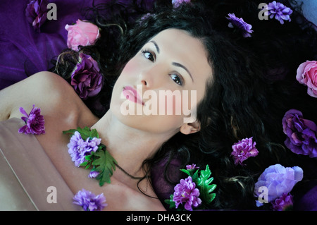 Ritratto di una giovane donna bellissima giacente sul letto Foto Stock