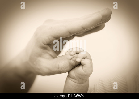 Concetto di amore e famiglia. Mani di madre e bambino closeup Foto Stock