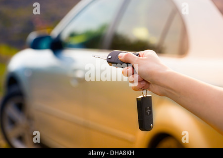 Le donne la mano preme sul telecomando auto sistemi di allarme Foto Stock