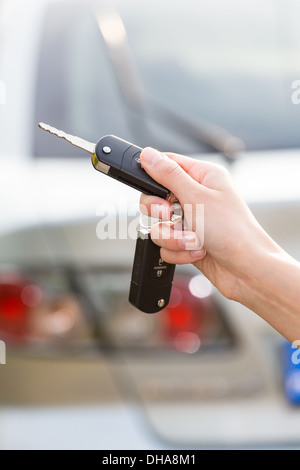 Le donne la mano preme sul telecomando auto sistemi di allarme Foto Stock