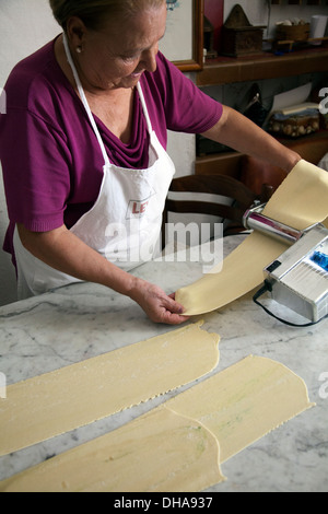 La donna la preparazione di pasta alimentare rolling out attraverso la macchina Foto Stock