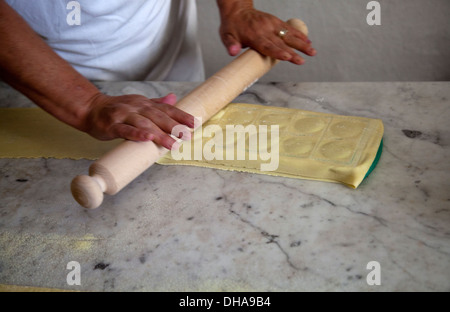 La donna la preparazione di pasta alimentare e di ribaltamento del vassoio Ravioli con ripieno Foto Stock