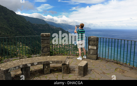 Madeira Portogallo. Un turista utilizzando un ipad dispositivo tablet per scattare una fotografia dell'isola scenario Foto Stock