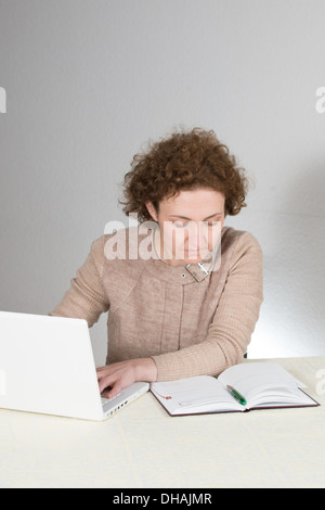 Giovane donna ricci lavora come contabile (ragioniere) Foto Stock
