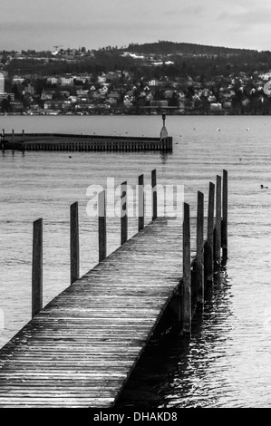 Il molo di legno sul lago di Zurigo in un giorno d'inverno. Versione in bianco e nero. Foto Stock