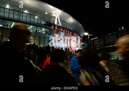 Una vista di Emirates Stadium, casa Arsenal Football Club come fan fare il loro modo per una partita di notte Foto Stock