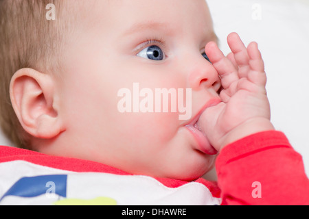 Bambino di sei mesi succhiare il pollice - dentizione Foto Stock