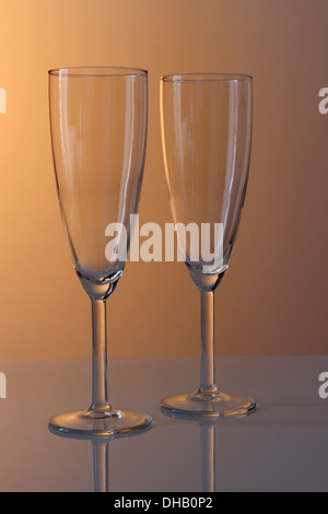 Una coppia di champagne vuota bicchieri in calda illuminazione studio Foto Stock
