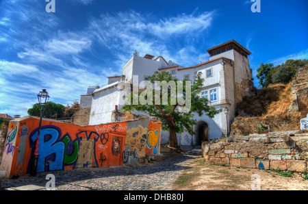 Una casa in un cantiere con una parete spruzzato con graphitti Foto Stock