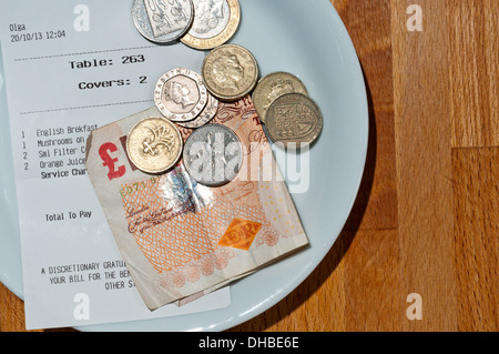 A sinistra di denaro come pagamento con fattura su un piattino in un ristorante o bar. Foto Stock