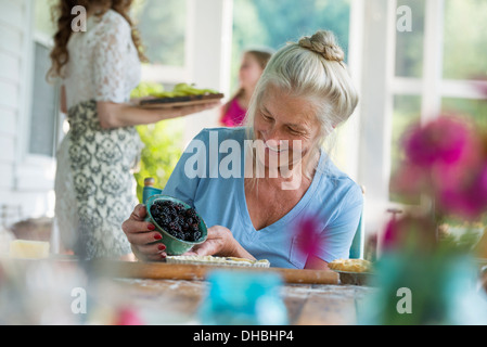 Una festa di famiglia in una casa colonica nel paese nello Stato di New York. Una donna matura vaschetta di contenimento delle carni di more. Foto Stock