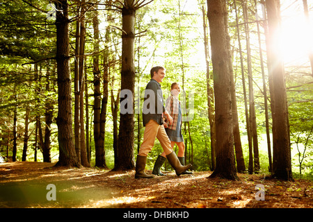 Tre persone, una famiglia passeggiate nel bosco nel tardo pomeriggio. Foto Stock