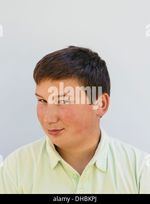 Ritratto di un ragazzo adolescente con corti capelli neri, guardando la telecamera e sorridente. Foto Stock