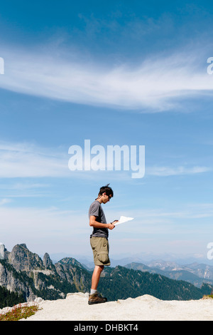 Un escursionista sul vertice di montagna guardando alla mappa. Sorpresa Alpine Lakes Wilderness a Mount Baker-Snoqualmie foresta nazionale, Foto Stock