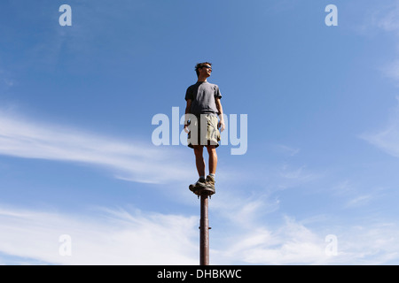 Uomo in piedi in equilibrio su montante metallico a guardare verso il cielo espansiva sorpresa Alpine Lakes Wilderness mt Foto Stock