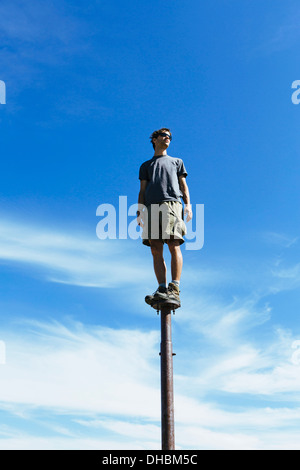 Uomo in piedi in equilibrio su montante metallico a guardare verso il cielo espansiva sorpresa Alpine Lakes Wilderness mt Foto Stock