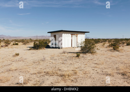 Un piccolo edificio abbandonato nel deserto di Mojave paesaggio. Foto Stock