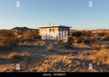 Un piccolo edificio abbandonato nel deserto di Mojave paesaggio. Foto Stock