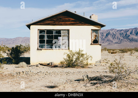 Un piccolo edificio abbandonato nel deserto di Mojave paesaggio. Foto Stock