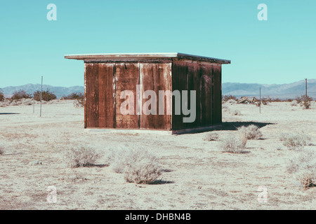 Un piccolo edificio abbandonato nel deserto di Mojave paesaggio. Foto Stock