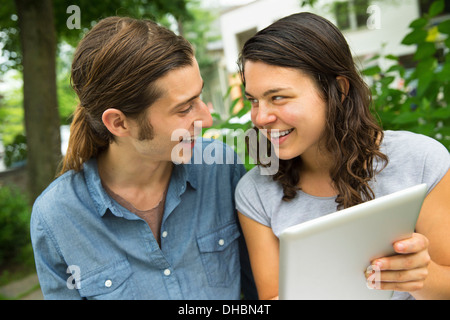 Una giovane coppia affiancati, flirtare e scattare fotografie. Foto Stock