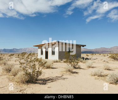 Un piccolo edificio abbandonato nel deserto di Mojave paesaggio. Foto Stock