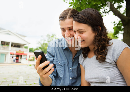 Una giovane coppia affiancati, flirtare e scattare fotografie. Foto Stock