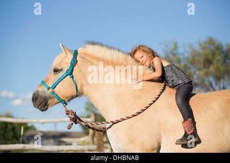 Una giovane ragazza seduta su un cavallo. Foto Stock