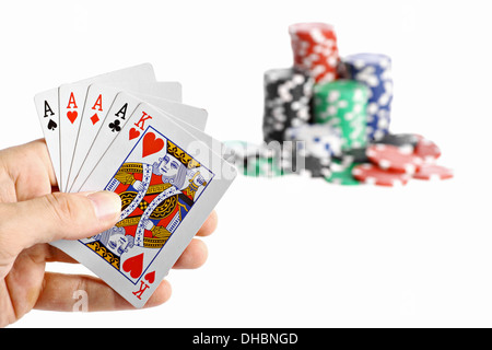 Una mano di poker tenendo un quattro di un tipo con poker chips in background Foto Stock